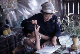 Mujer junto a niña con cuaderno