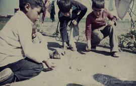 Niños jugando a las bolitas