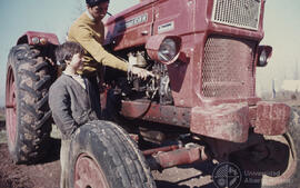 Adulto enseñando un tractor a niño