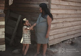 Mujer embarazada junto a niña pequeña
