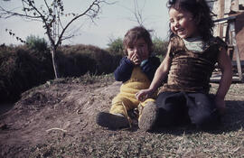 Dos niños pequeños junto a una acequia