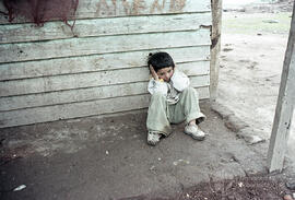 Niño sentado en el suelo tapando sus oídos