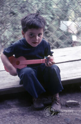 Niño con una guitarra de juguete
