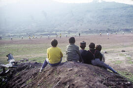 Grupo de niños viendo un partido de futbol