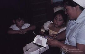 Mujer junto a dos niñas pequeñas, recorta caja de leche