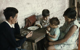 Niño tomando té y comiendo pan junto a la familia