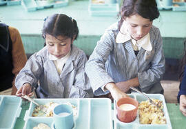 Dos niñas comiendo en el interior de una escuela